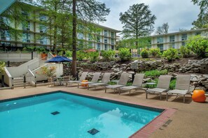 A swimming pool with lounge chairs and a stone wall. - Marriott St. Louis Airport (St. Louis)