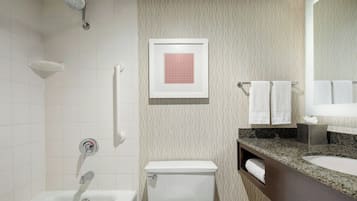 Un baño moderno con bañera, inodoro, tocador con lavabo y ducha.