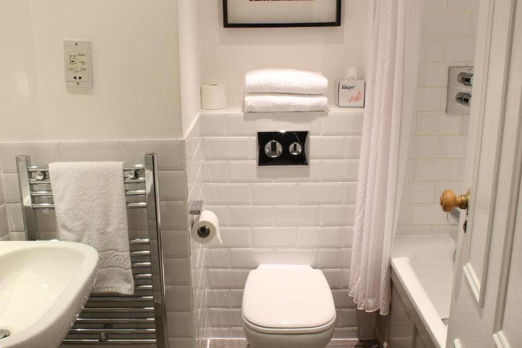A bathroom with a white sink, a toilet, and a shower area.