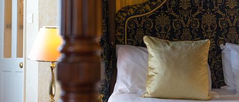 Una habitación de hotel con una cama, una mesita de noche y una lámpara.