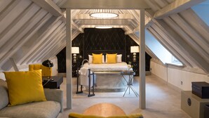 An attic bedroom with a bed, bedside tables, a desk, and a bathtub. - Best Western Red Lion Hotel (Salisbury)