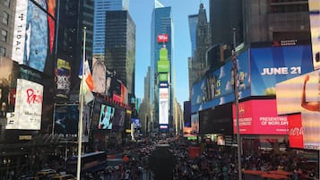 A busy urban street scene with tall buildings and numerous billboards.