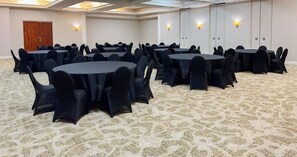 A conference room with multiple round tables and chairs, carpeted floor, and wall-mounted lighting. - Best Western Plus Palm Beach Gardens Hotel & Suites and Conference Ct (North Palm Beach)
