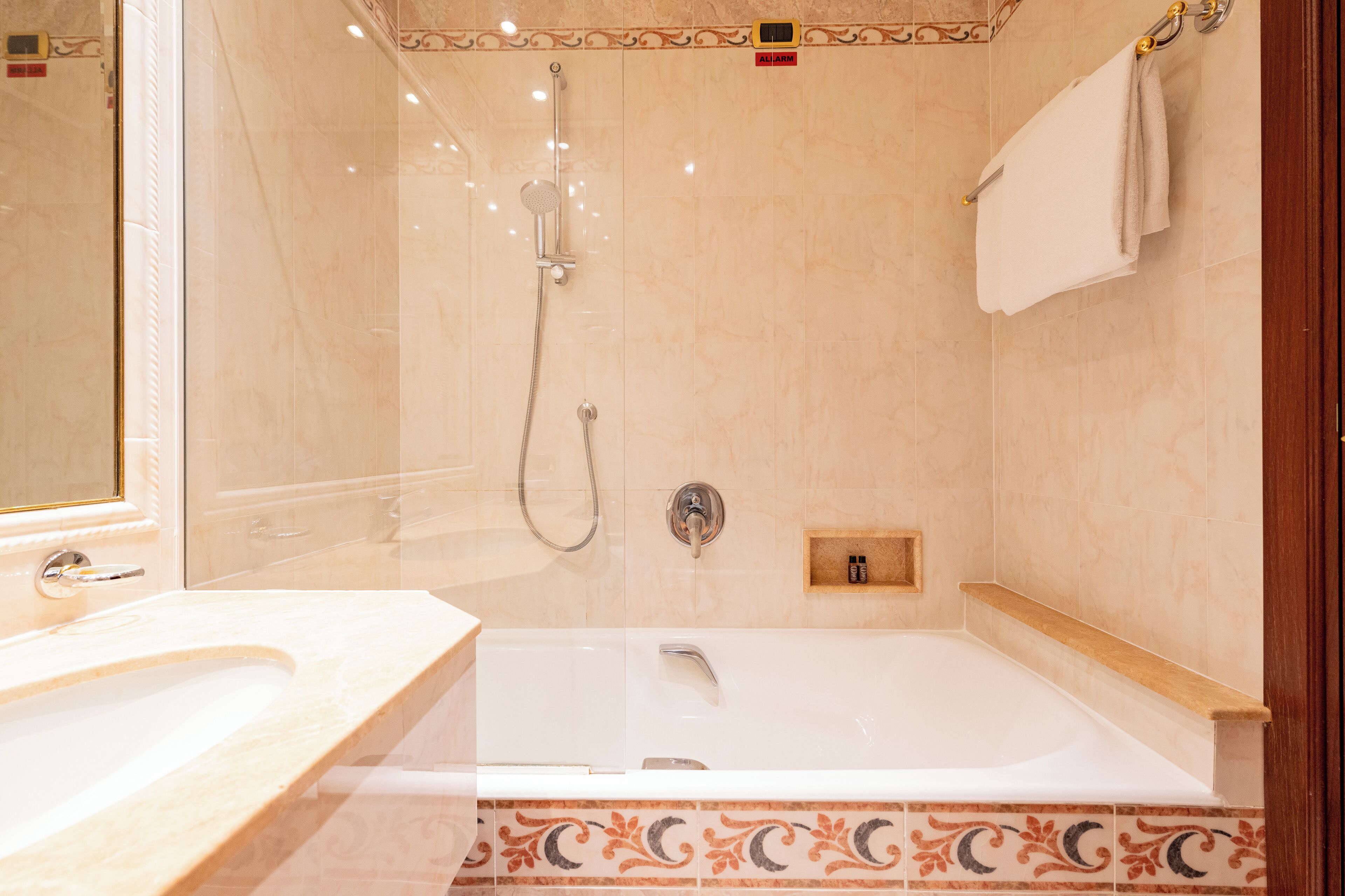 A modern bathroom with a bathtub, shower, and vanity.
