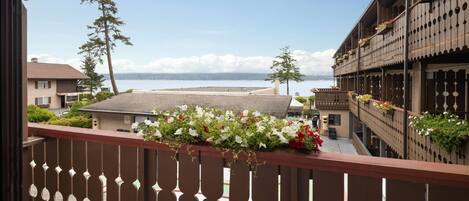 A balcony with a view of a body of water and buildings.