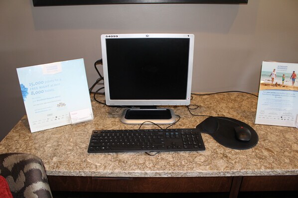Configuración de computadora de escritorio con monitor, teclado y ratón sobre una encimera de granito.