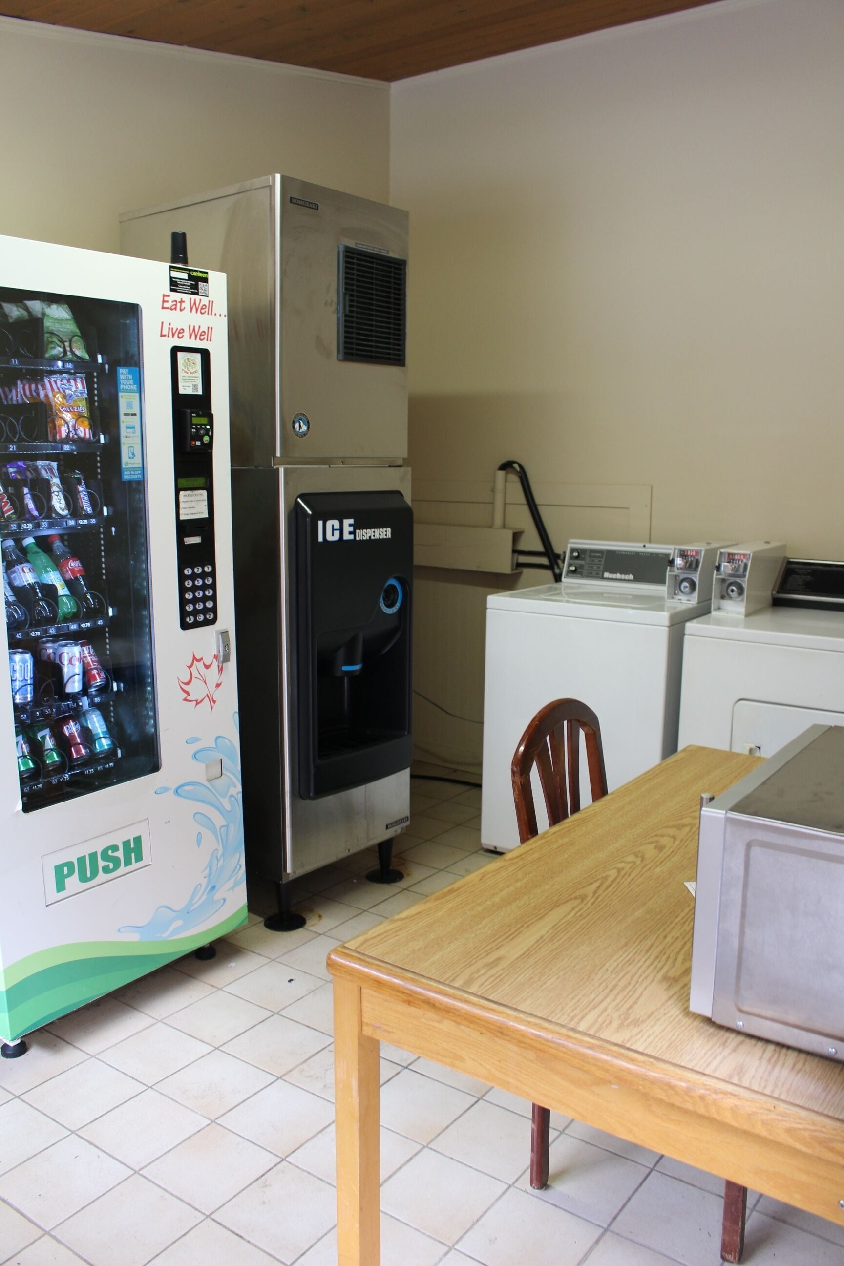A kitchenette with a refrigerator, microwave, and ice dispenser.