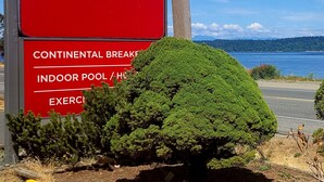 Ein rotes Schild für Ramada by Wyndham, das Annehmlichkeiten wie ein kontinentales Frühstück, ein Hallenbad und Fitnessmöglichkeiten hervorhebt.