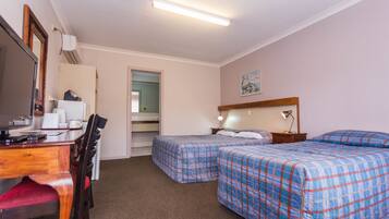 A hotel room with two beds, a desk with a chair, a TV, and a mirror.