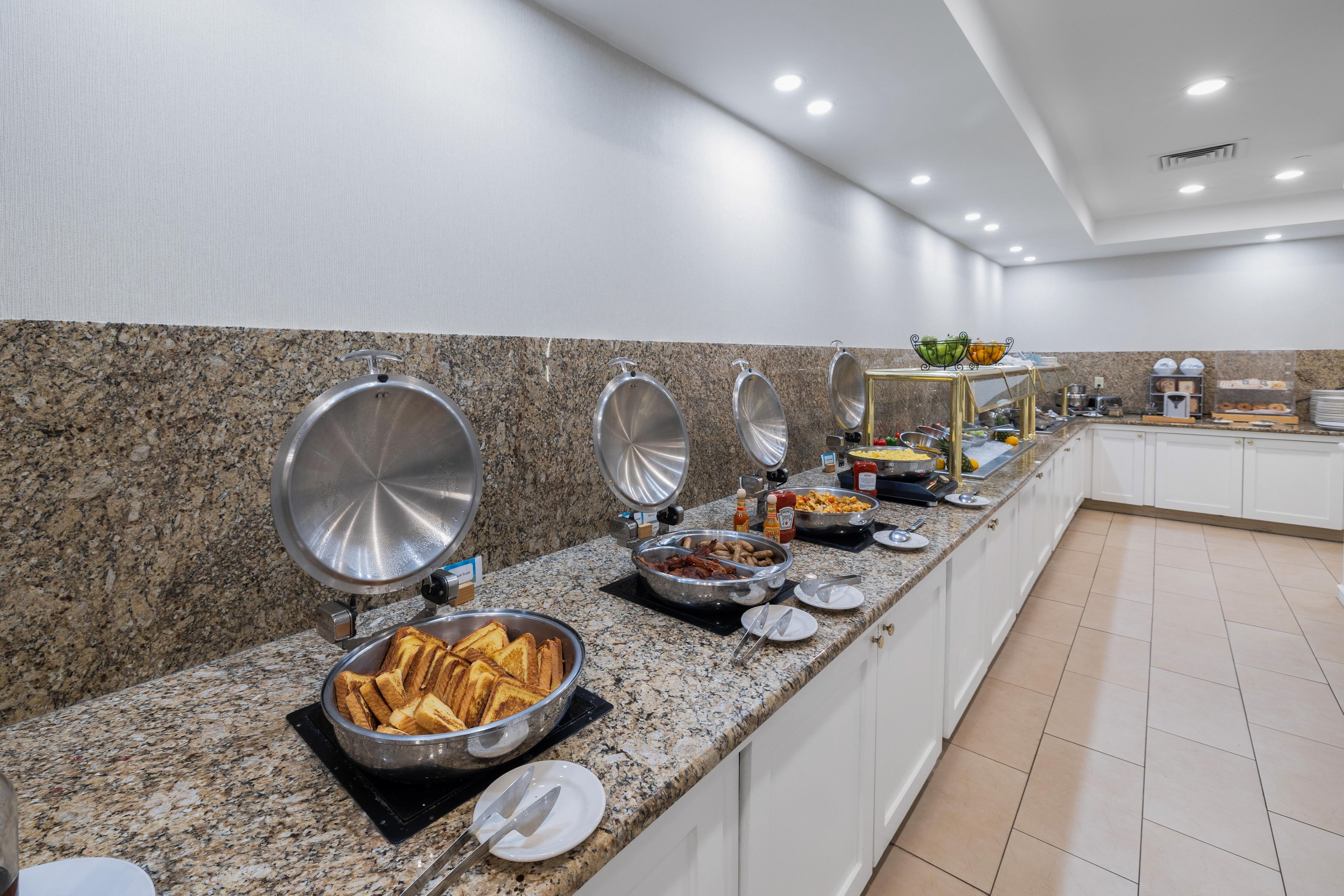 A buffet setup with various food items and utensils.