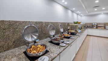 A buffet setup with various food items and utensils.