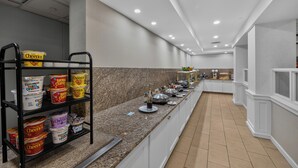 Un buffet proposant une variété de plats et un espace où les clients peuvent eux-mêmes se servir des boissons.