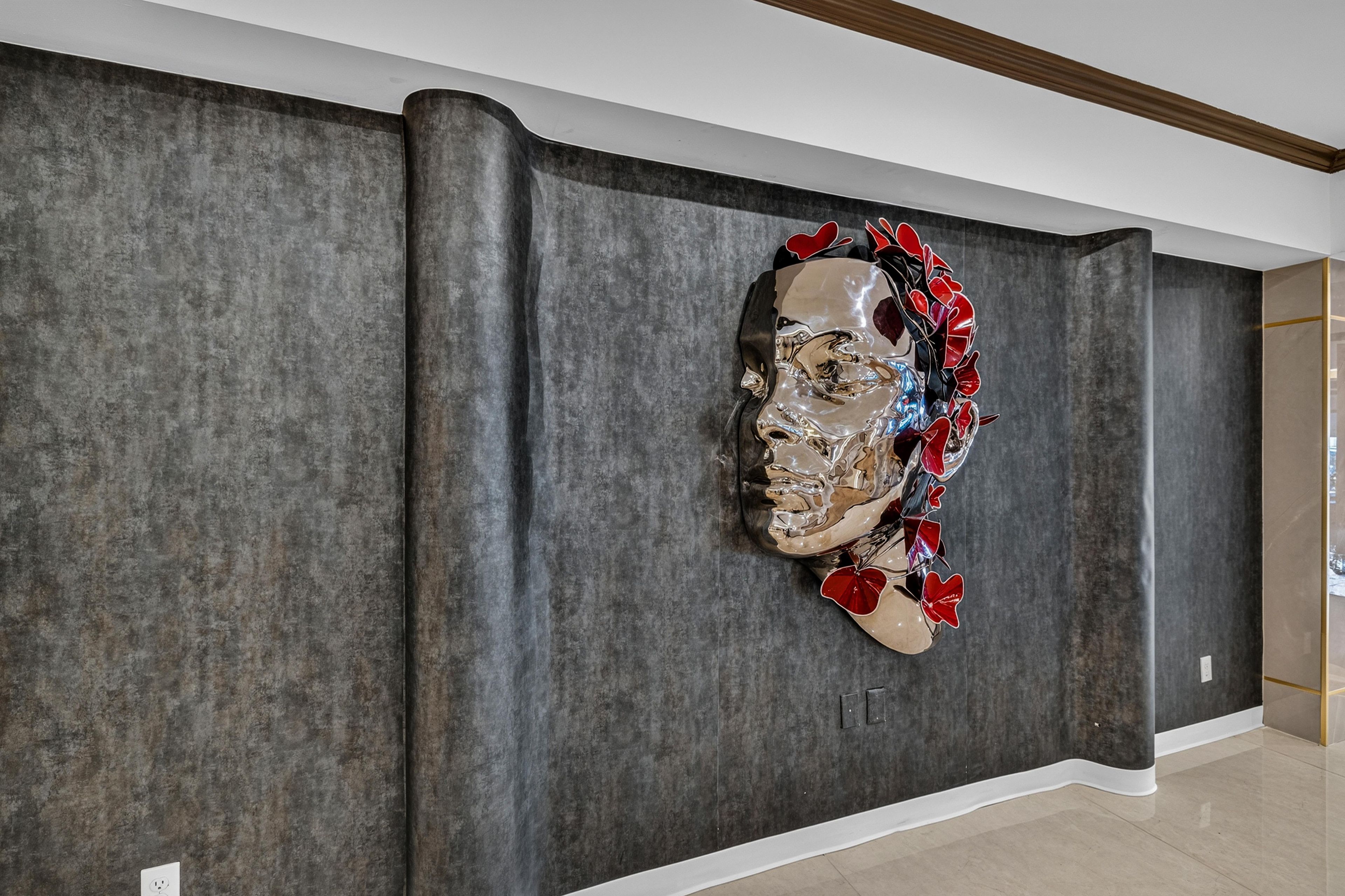 Un interior moderno con una pared texturizada y una escultura decorativa de metal.