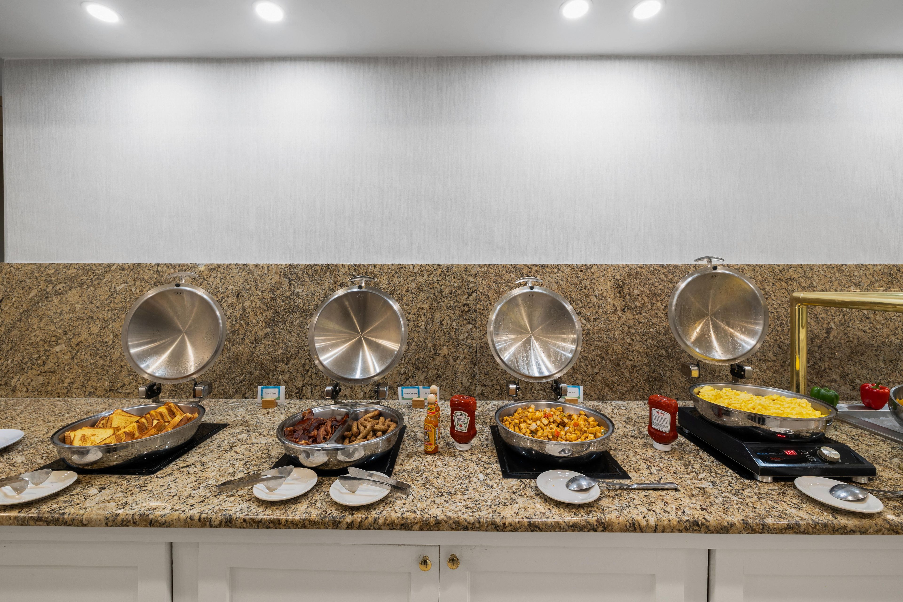 A buffet setup with various food items and condiments.