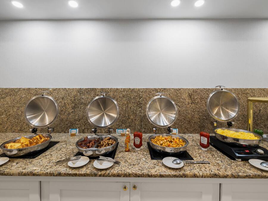 A buffet setup with various food items and condiments.