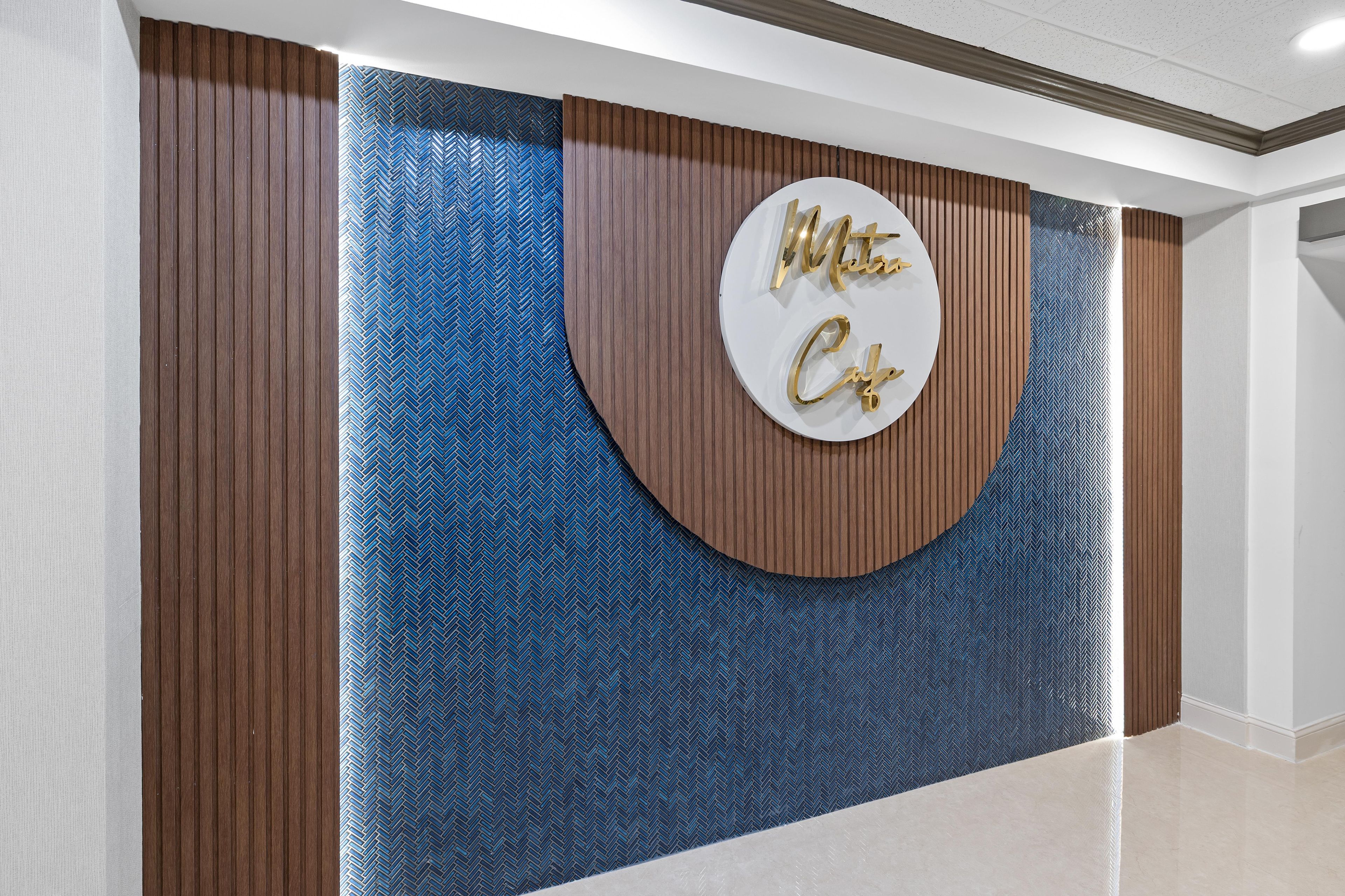 A reception area with a circular sign that reads 'Metro Cafe' and a herringbone patterned wall.