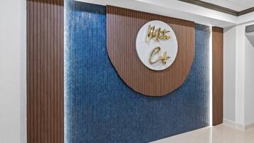 A reception area with a circular sign that reads 'Metro Cafe' and a herringbone patterned wall.