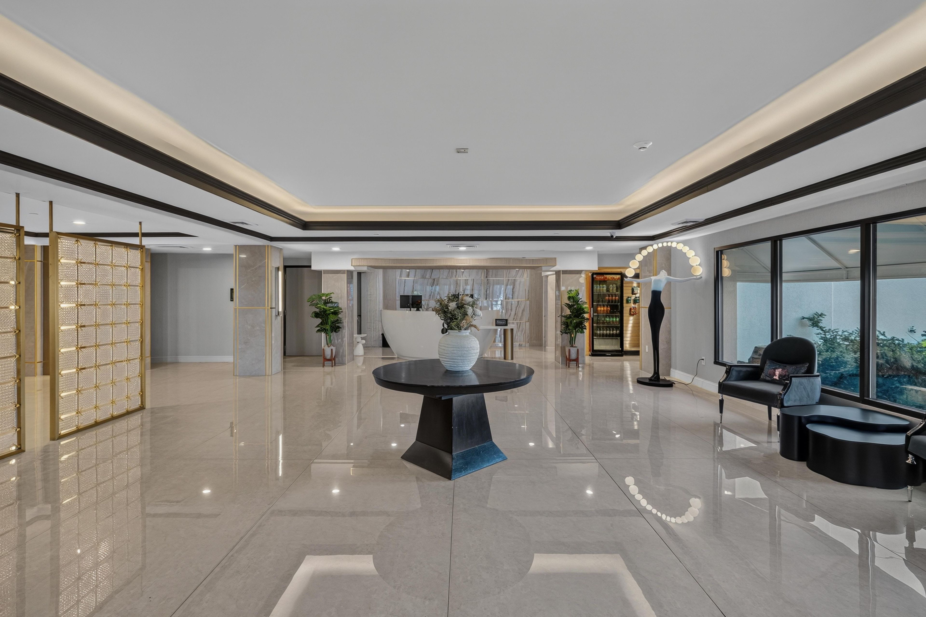 Un hall d’entrée moderne avec une table ronde centrale, des espaces de détente et un comptoir d’accueil.