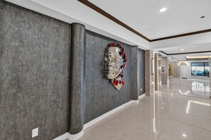 A hallway with a modern art sculpture on the wall, a polished floor, and a view of the outside through a window. - DoubleTree by Hilton Downtown Wilmington - Legal District (Wilmington)