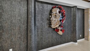 Un intérieur moderne avec un mur texturé et une grande sculpture abstraite.
