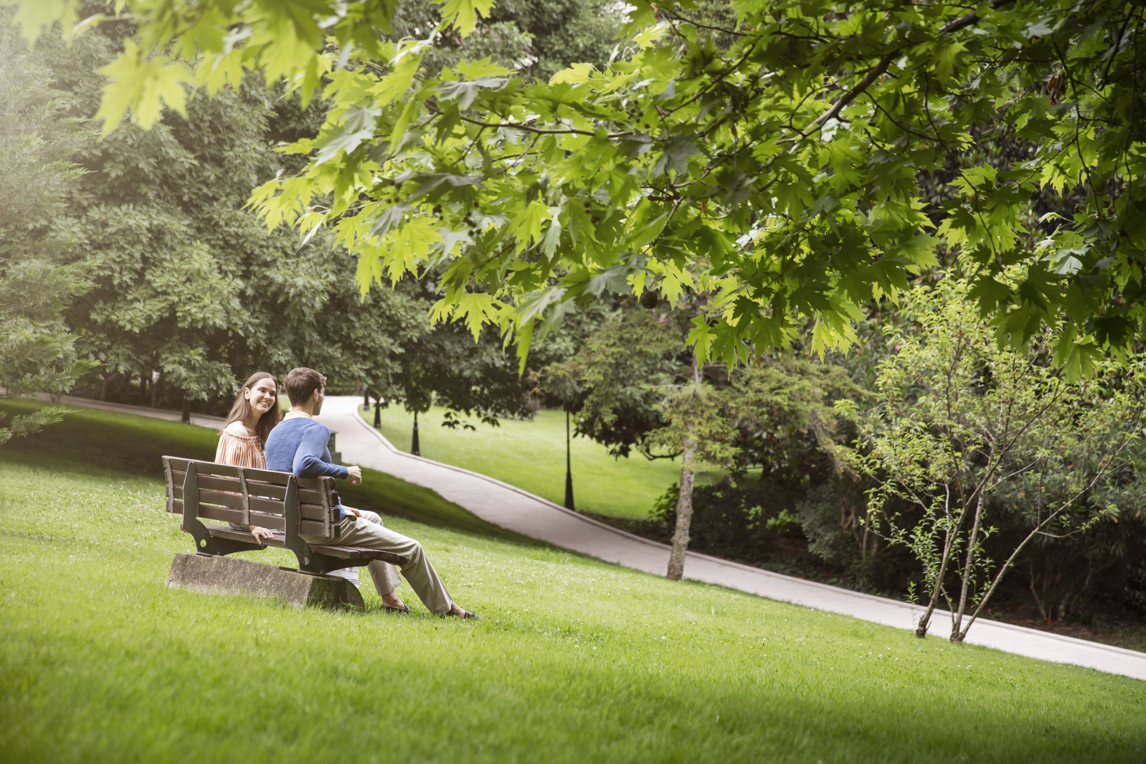 A park bench with a couple sitting.