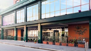A hotel with a modern glass facade, a ground-level entrance, and a sign reading "BLAISE & FRANCIS". - Hotel Blaise & Francis (Milan)