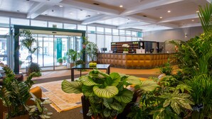 A spacious lobby with a reception desk, seating area, and large windows. - Hotel Blaise & Francis (Milan)