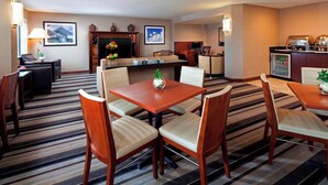 Une chambre d’hôtel comprenant un coin repas, une cheminée, une télévision et un minibar.