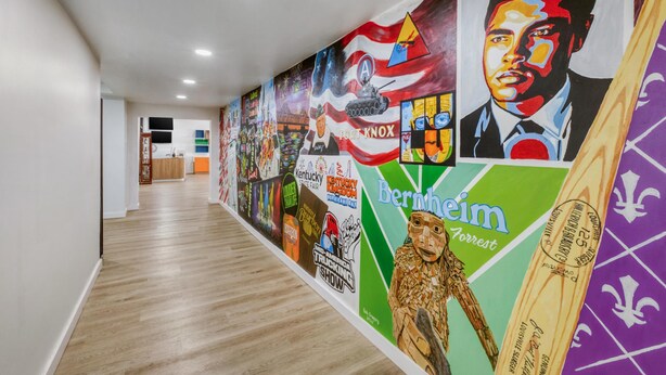 A hallway with a mural featuring various logos and images, including Kentucky State Fair and Fort Knox. - Best Western Shepherdsville-Louisville South Hotel (Shepherdsville)