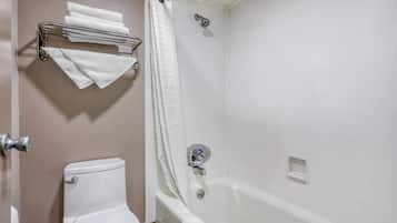 Un baño con inodoro, bañera y cortina de ducha.