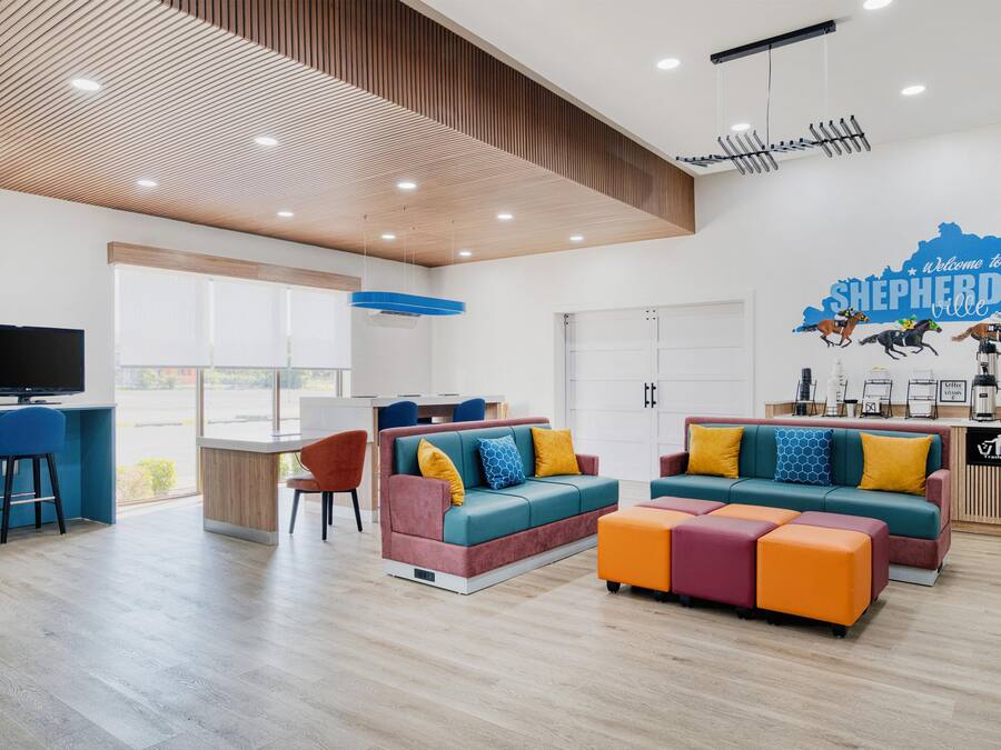 A modern living room with a television, seating area, and a wall mural.