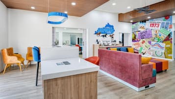 A modern interior with a reception desk, seating area, and a wall decorated with Kentucky Derby memorabilia.