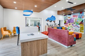 A modern interior with a reception desk, seating area, and a wall decorated with Kentucky Derby memorabilia. - Best Western Shepherdsville-Louisville South Hotel (Shepherdsville)