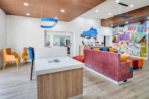 Un interior moderno con una mesa de recepción, área de descanso y una pared decorada con recuerdos del Kentucky Derby.