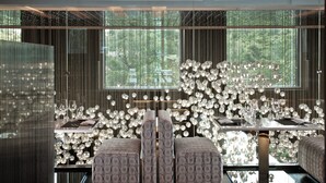 A modern interior with a dining area featuring a glass table, cushioned seating, and a decorative light fixture. - The Mira Hong Kong Hotel (Kowloon)