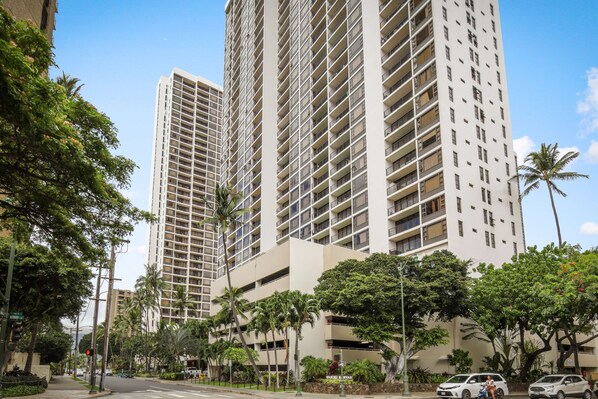 Un edificio moderno de gran altura con varios pisos, ventanas amplias y balcones.