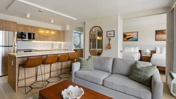 A modern living space with a kitchen, dining area, and a sofa set.