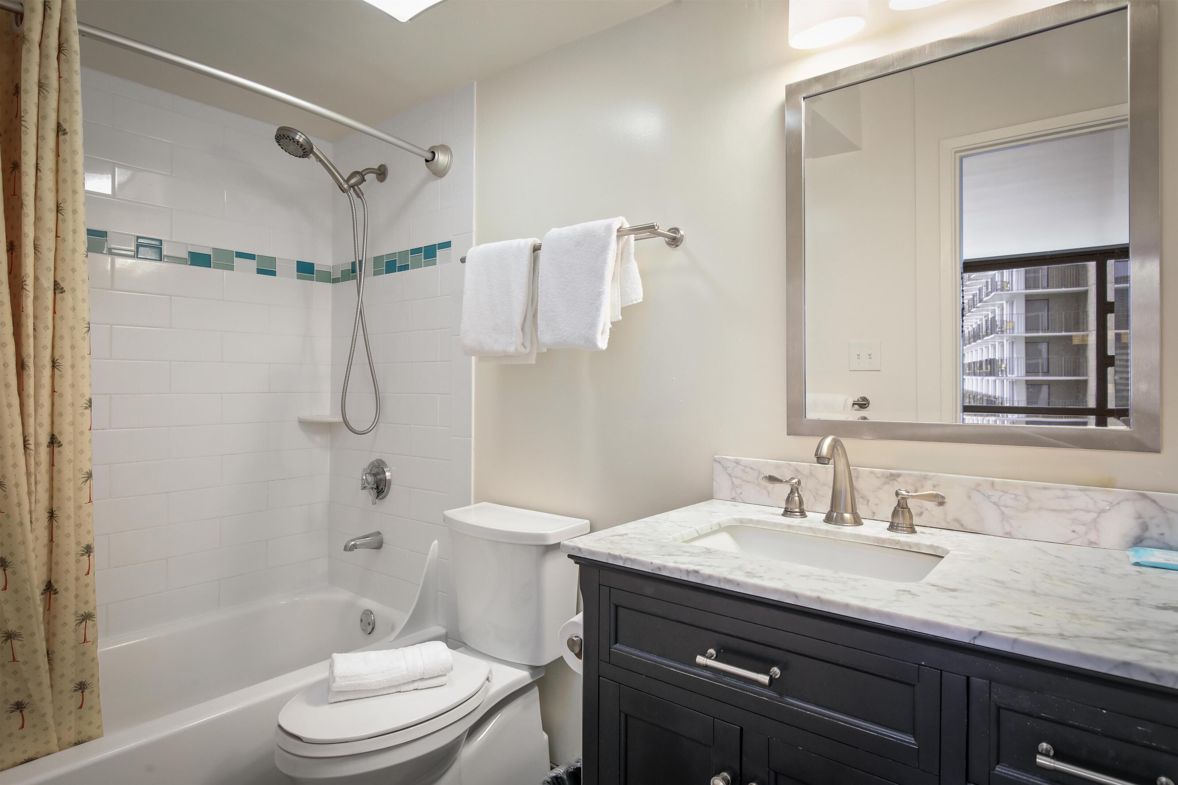 A bathroom with a bathtub, toilet, and sink.