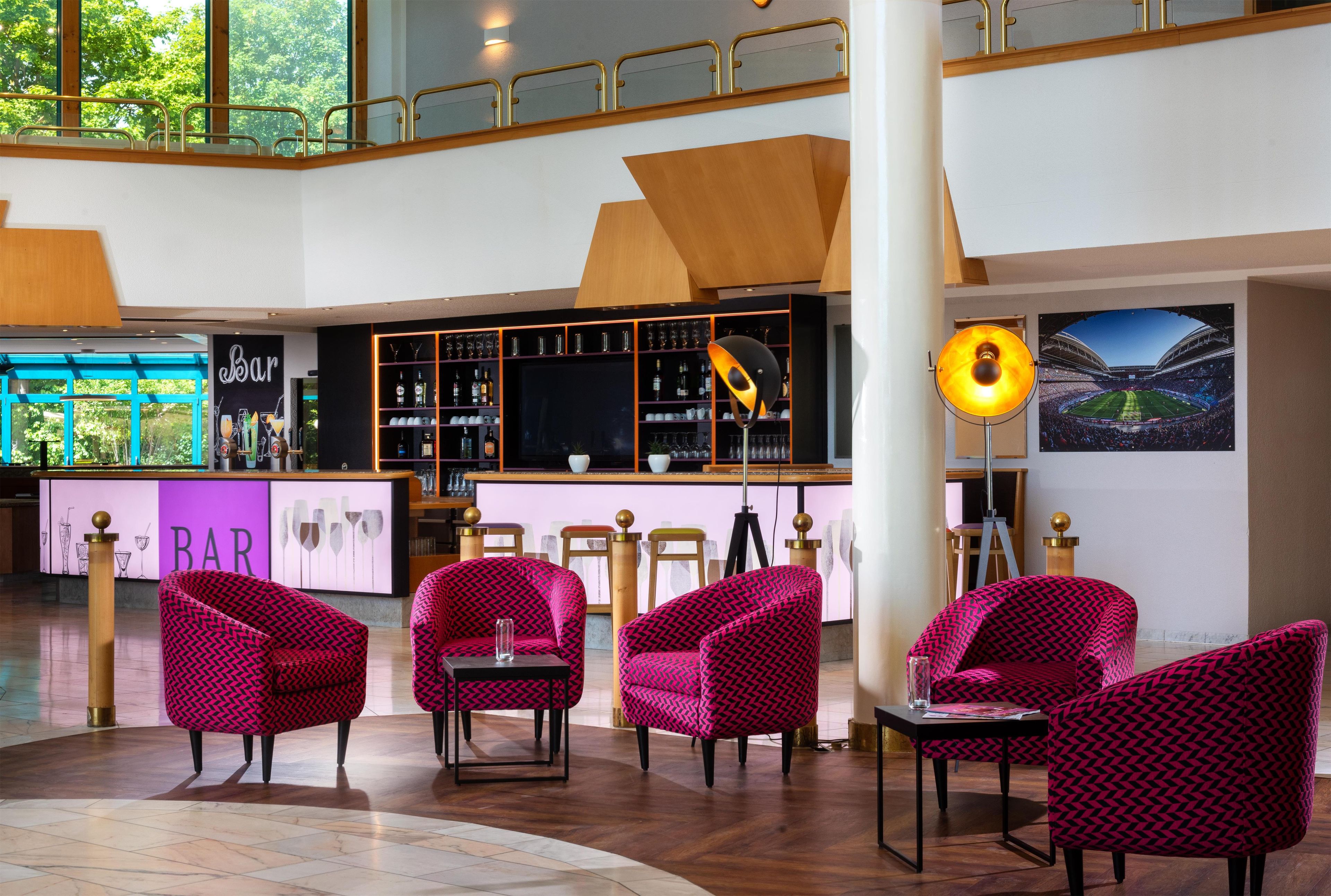 A bar area with seating and a large screen.