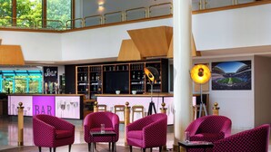 A bar area with seating and a large screen.
