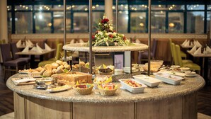 A buffet setup with various food items and a floral centerpiece on a granite island.