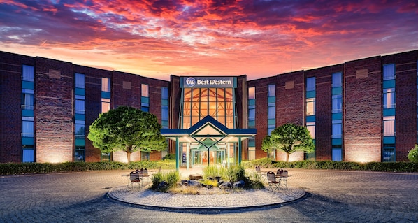 A hotel with a central entrance, brick facade, and a sign reading 'Best Western.'