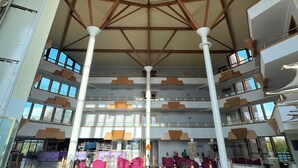 A spacious atrium with high ceilings, multiple levels, and a central open area with seating.