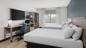 Una habitación de hotel con cama, escritorio, silla y televisor.