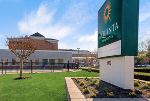 La Quinta Inn Suites 600 offers a welcoming entrance with a beautifully manicured lawn and a modern hotel building in the background.