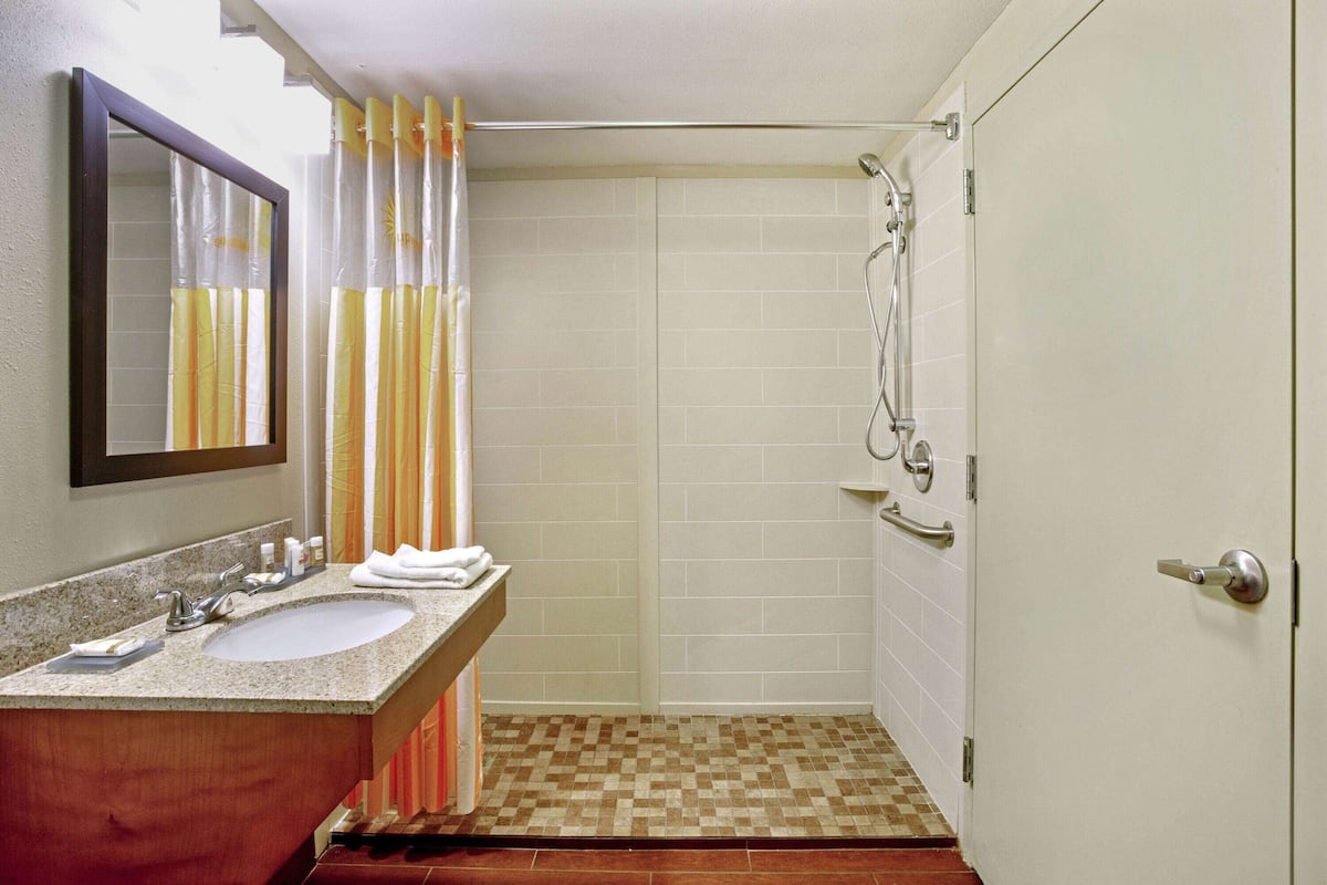 Chambre, 1 trÚs grand lit, accessible aux personnes à mobilité réduite (Mobility Accessible) | Salle de bain | Ensemble douche/baignoire, articles de toilette gratuits, sÚche-cheveux