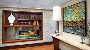 A modern interior with a fireplace, wooden shelves, and a large abstract painting. - Sheraton Ottawa Hotel (Ottawa)