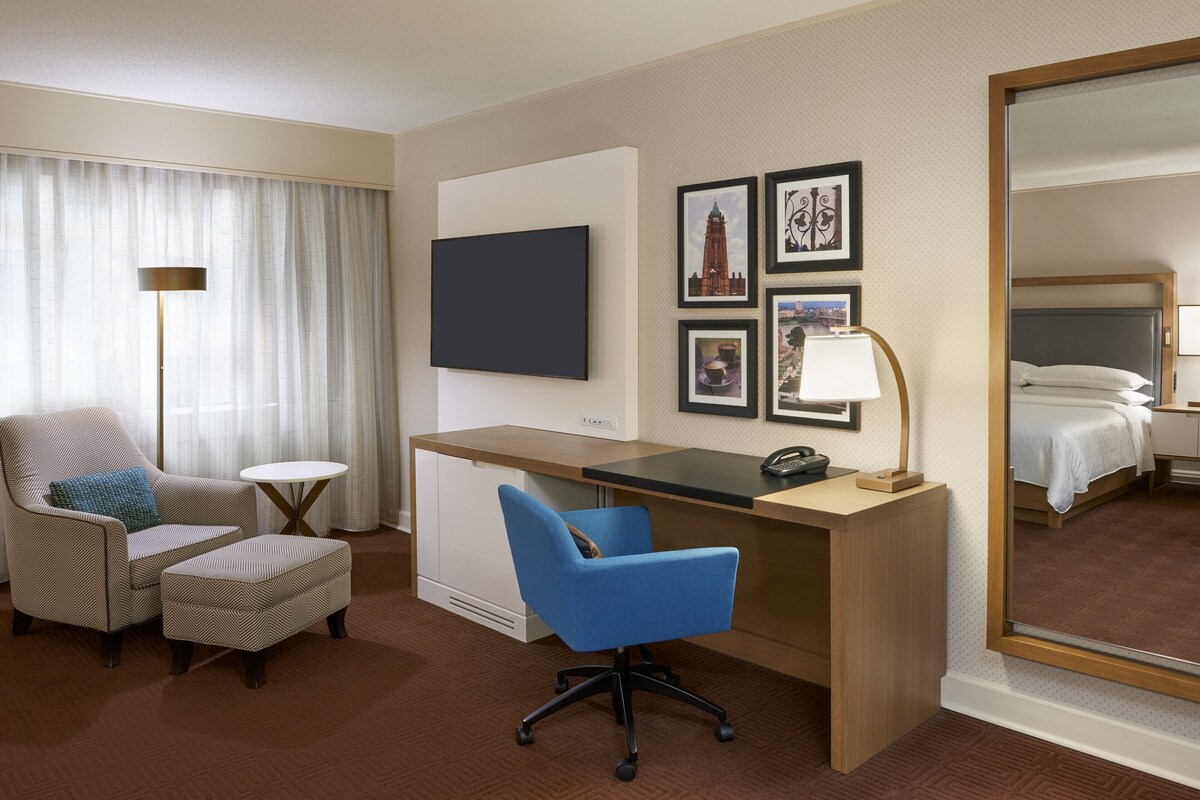 Una habitación de hotel con escritorio, silla y cama.