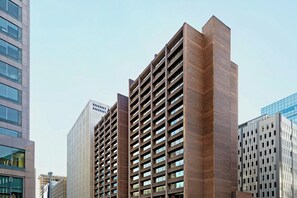 Un edificio moderno de gran altura con fachada de ladrillo y una cuadrícula de ventanas.