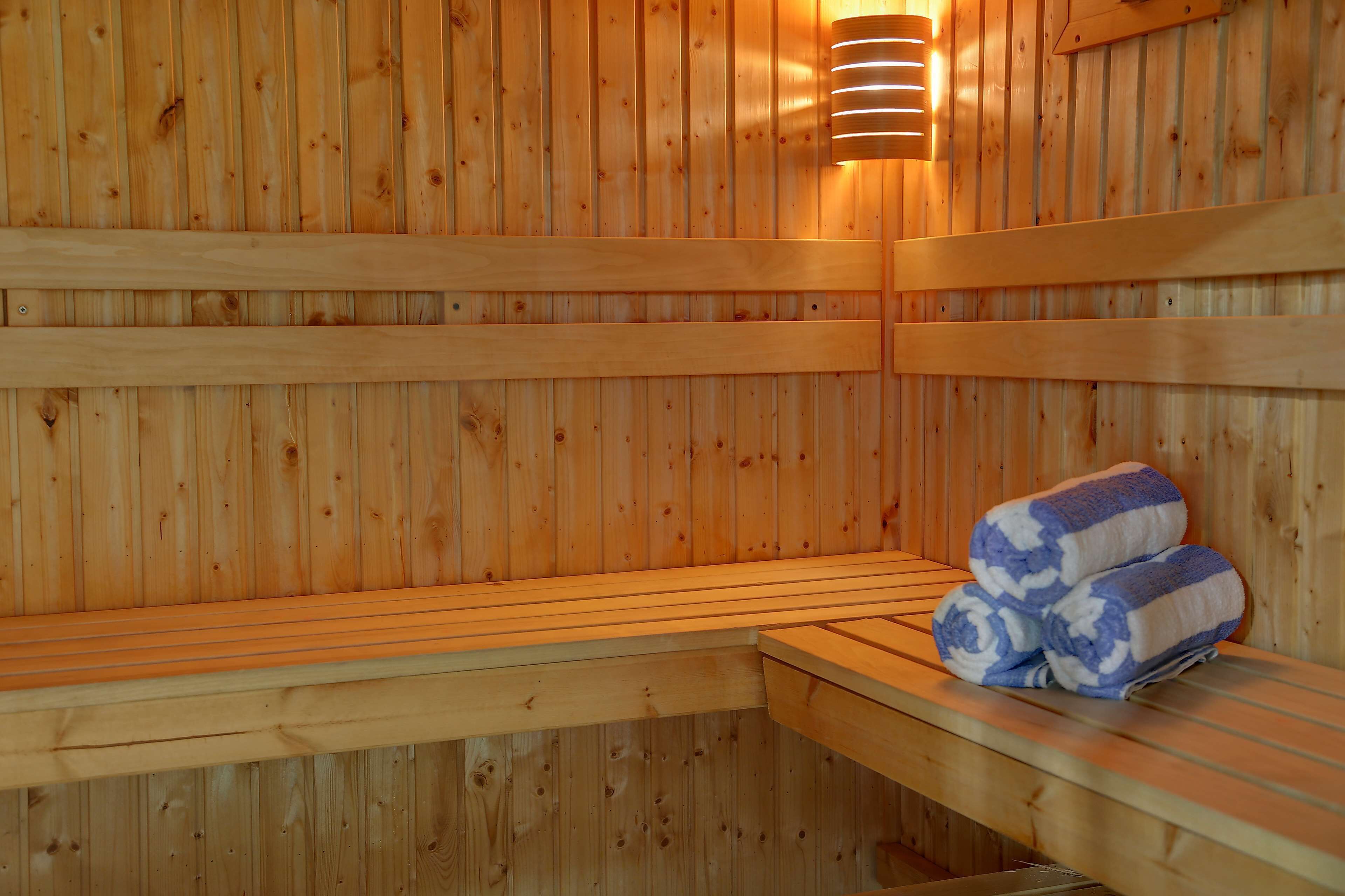 A wooden sauna with benches and a bench with towels.